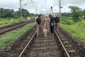Police officers interrogate suspects in the Raigad murder case, sitting across a table with case files and a mobile phone.